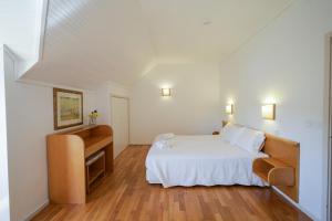 een slaapkamer met een wit bed en een bureau bij Morgado - River Suites and Houses by PCH in Padrões