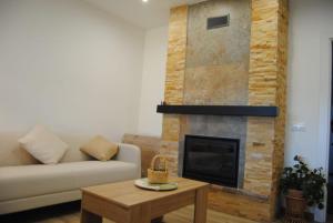 sala de estar con sofá y chimenea en Chalet Pinara, en El Barraco