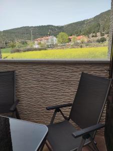 2 sillas en un balcón con vistas a un viñedo en Chalet Pinara, en El Barraco
