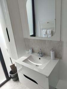 a white bathroom with a sink and a mirror at Grey Diamond in Târgu-Mureş +27 photos