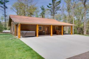 a log cabin with a large driveway at Hatfield Vacation Rental with Private Hot Tub! in Merrillan