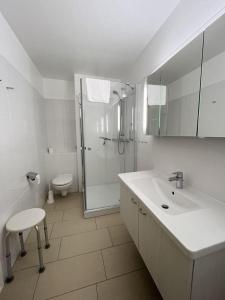 une salle de bain avec douche, lavabo et toilettes dans l'établissement Germania-41, à Sankt Peter-Ording