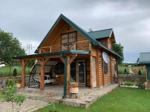 una baita di tronchi con veranda e patio. di Guest House 