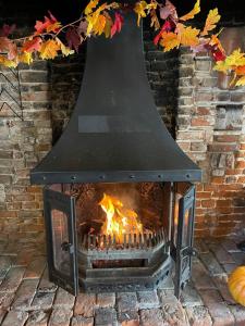 a fireplace with a large bell above it at The Rose and Crown in Elham