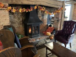 a living room with a brick fireplace with a stove at The Rose and Crown in Elham