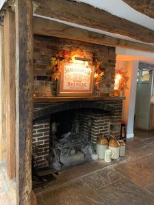 a brick fireplace with a sign above it at The Rose and Crown in Elham