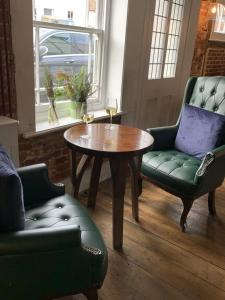 een kamer met 2 stoelen en een tafel en 2 stoelen bij The Rose and Crown in Elham