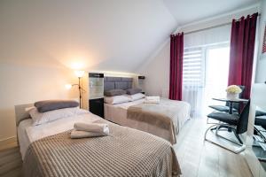 a hotel room with two beds and a window at Pokoje na Żurawiej 10 in Mikołajki