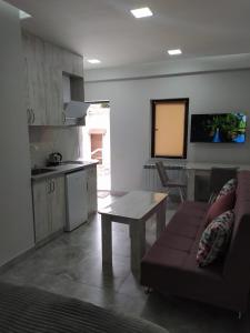 een keuken en een woonkamer met een bank en een tafel bij Apart hotel Alex in Jerevan