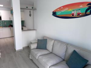 a living room with a couch and a painting on the wall at Casa Malakita with private seaview roof terrace in Conil de la Frontera