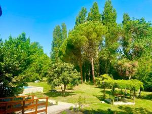 um parque com bancos e árvores num dia ensolarado em Domaine d'Ella Jourre em Canet d'Aude