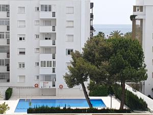a view of a building with a tree and a swimming pool at 5 Salou,Playa,Piscina cento PARKING in Salou