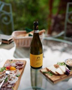 una botella de vino sentada junto a un plato de comida en Cascina Binè en Novi Ligure