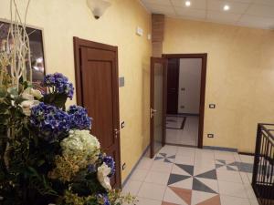 a hallway with two doors and purple and white flowers at B&B Il Portico in Praticello di Gattatico