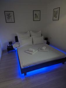 Schlafzimmer mit einem Bett mit blauem Licht in der Unterkunft Lake House Anemona in Buhalniţa