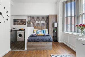 een kleine slaapkamer met een bed en een keuken bij Perfect Location for Long Stays in Leicester