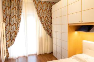ナポリにあるFolly Apartmentのベッドと窓のある小さな部屋 +4枚の写真