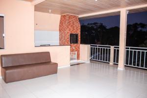 a living room with a couch on a balcony at Residencial Havaí in Guaratuba