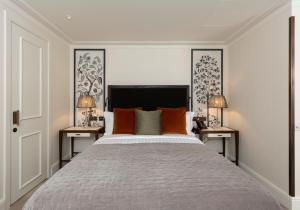 a bedroom with a large bed with orange pillows at The City of London Club in London