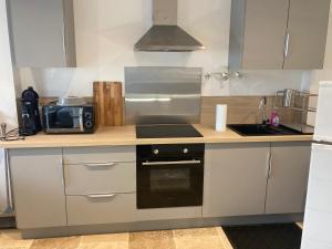 a kitchen with a stove and a microwave at Appartement neuf coeur du village in Saintes-Maries-de-la-Mer