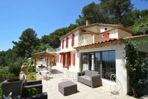 a house with red windows and a patio at Bastide vue exceptionnelle in Aix-en-Provence