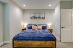 Schlafzimmer mit einem Bett mit blauer Decke in der Unterkunft Cozy Denver Vacation Rental Near Broncos Stadium! in Denver