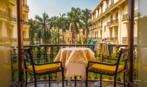 a table and chairs on a balcony with a table at The Oberoi Grand Kolkata in Kolkata