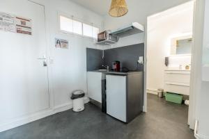 eine kleine Küche mit Spüle und Kühlschrank in der Unterkunft Studio Ernest Chamalières Calme Parking Gratuit in Chamalières