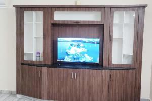um grande centro de entretenimento em madeira com uma televisão de ecrã plano em 2 BHK Fully Furnished in Kukatpally #201 em Hyderabad