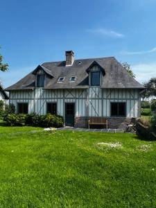 una gran casa blanca con un banco en un patio en Ailleurs sous les étoiles, en Manneville-la-Raoult