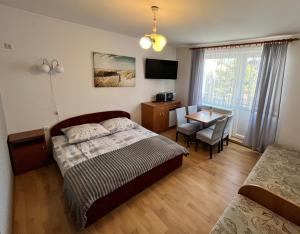 カルビアにあるPokoje Gościnne U RYBAKAのベッドルーム1室(ベッド1台、テーブル、デスク付)