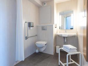 a white bathroom with a toilet and a sink at B&B HOTEL Rennes Ouest Villejean in Rennes