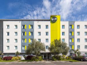 B&B HOTEL Rennes Ouest Villejean في رين: مبنى أبيض كبير مع علامة bdb عليه