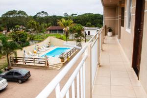 a balcony with a view of a swimming pool at Residencial Havaí in Guaratuba