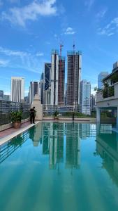 a swimming pool with a city skyline in the background at Embassy Home KLCC Jalan Ampang in Kuala Lumpur