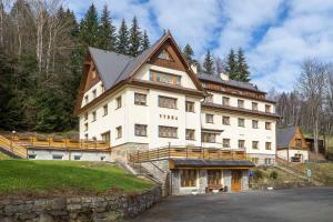 un grande edificio bianco in cima a una collina di Samoobslužný hotel Vydra a Srní