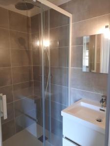 a bathroom with a glass shower and a sink at Le Grand Hotel in Aups