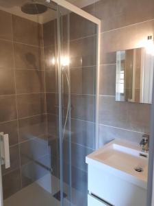 een badkamer met een glazen douche en een wastafel bij Le Grand Hotel in Aups