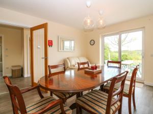 a dining room with a wooden table and chairs at Berg Cottage in Ballindalloch