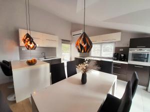 een keuken met een witte tafel en zwarte stoelen bij Luxury Apartment Mare in Brodarica