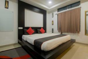 a bedroom with a large bed with red pillows at Super Collection O The Blu Bell Nizarapar Path in Guwahati
