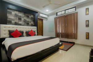 a bedroom with a large bed with red pillows at Super Collection O The Blu Bell Nizarapar Path in Guwahati