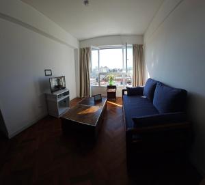 een woonkamer met een blauwe bank en een tv bij En el Centro in Salta