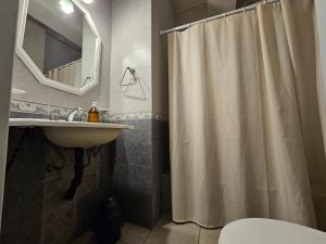 een badkamer met een douchegordijn en een wastafel bij En el Centro in Salta