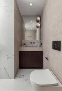 a bathroom with a white toilet and a sink at Luxury Suites by Lato in Agios Nikolaos