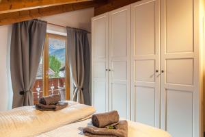 een slaapkamer met witte kasten en een raam bij Alpblick Apartment Zugspitze in Garmisch-Partenkirchen