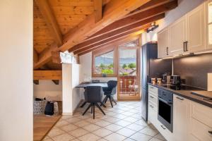 a kitchen with a table and chairs and a window at Alpblick Apartment Zugspitze in Garmisch-Partenkirchen