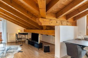 a living room with wooden ceilings and a table at Alpblick Apartment Zugspitze in Garmisch-Partenkirchen