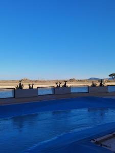 una piscina con la spiaggia sullo sfondo di Studio cabine au pied de la plage de St Cyprien avec piscine a Saint-Cyprien