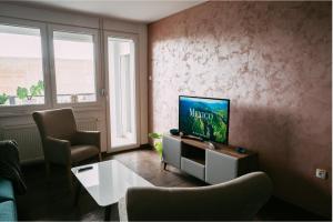 een woonkamer met een televisie en 2 stoelen bij Klicakn in Subotica